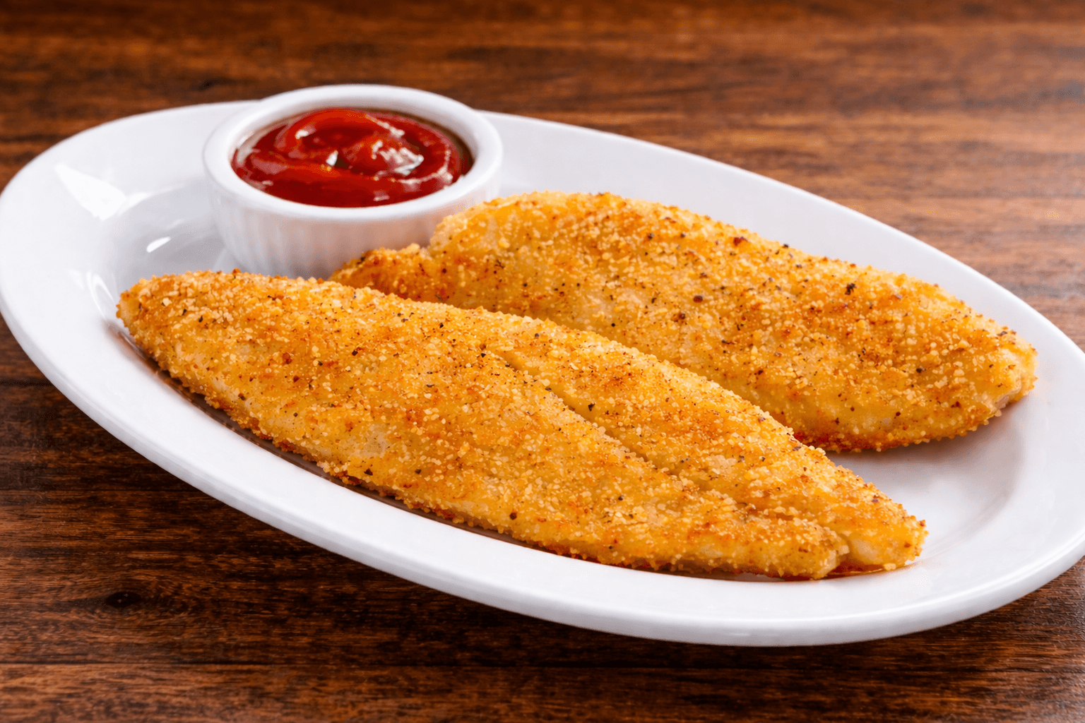 Crispy Fish - Golden breaded fish fillets served with ketchup dipping sauce.